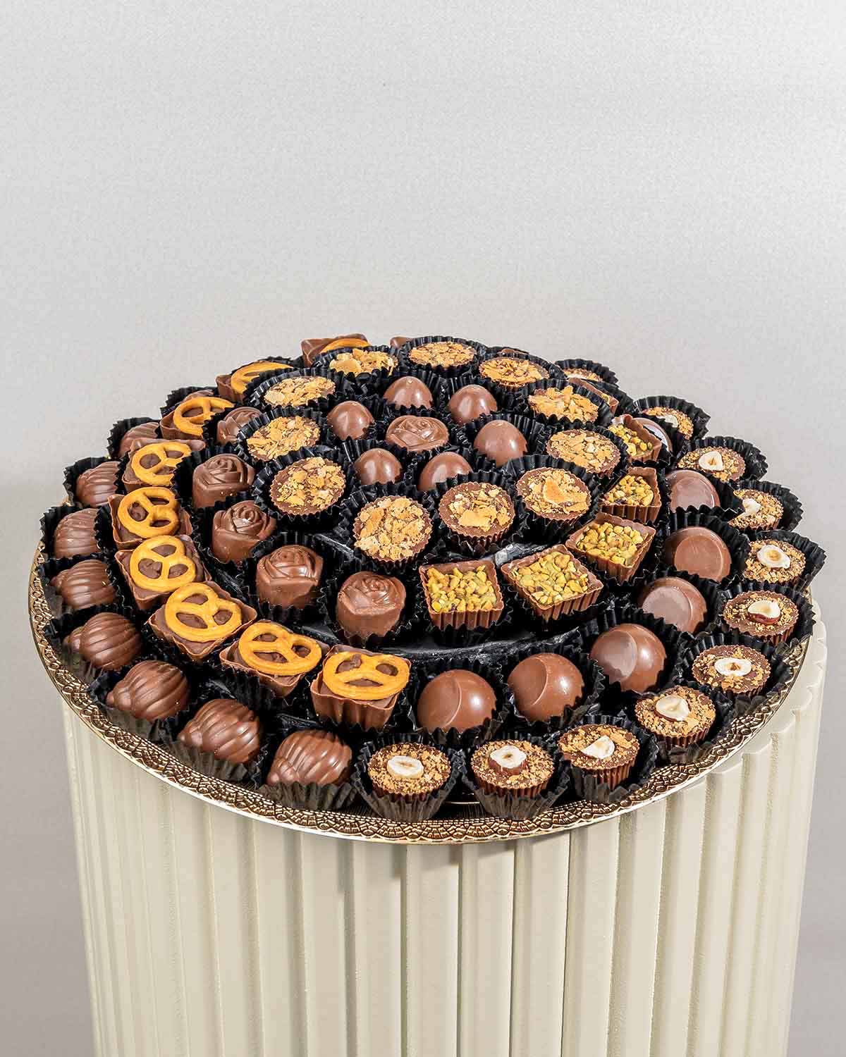 78 Assorted Chocolates ArrangementChocolate & ConfectioneryYour Gift Contains:• 78 assorted Belgian milk chocolates• Flavors: Pistachio, Hazelnut, Speculoos, Peanut Butter and Roche, Coconut, Date and Coffee• Chocolate Weight: 900g• Tray Dimension: 31x31c